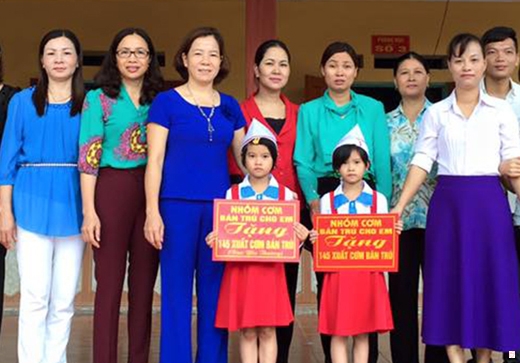 Cô Vũ Thị Thanh (thứ ba từ trái) trao suất cơm của Quỹ “Thiện nguyện cơm  bán trú cho em” cho học sinh có hoàn cảnh khó khăn