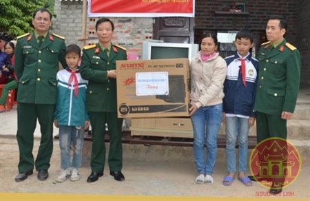 Đại diện Ban giám hiệu Trường Quân sự Quân khu 3 trao đồ dùng sinh hoạt tặng gia đình chị Dương Thị Mùi